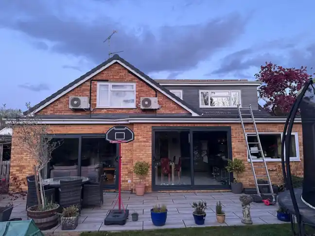 Rear of a chalet house with grey dormer and new tiled roof