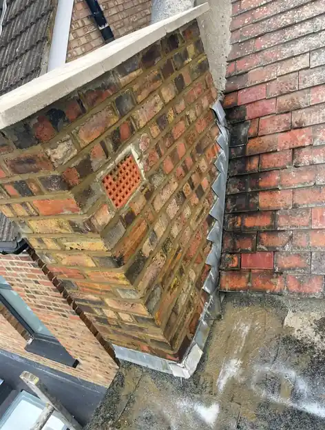 Brick chimney stack with new lead flashings dressed down onto the tiles