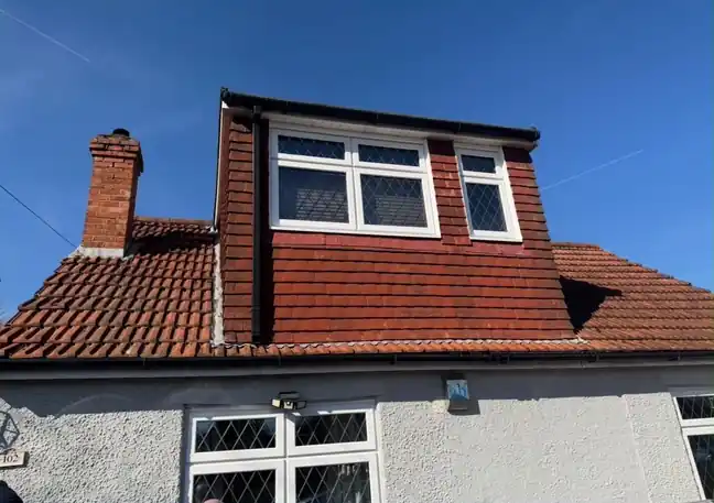 Dormer clad in red hanging tiles with white uPVC leaded windows