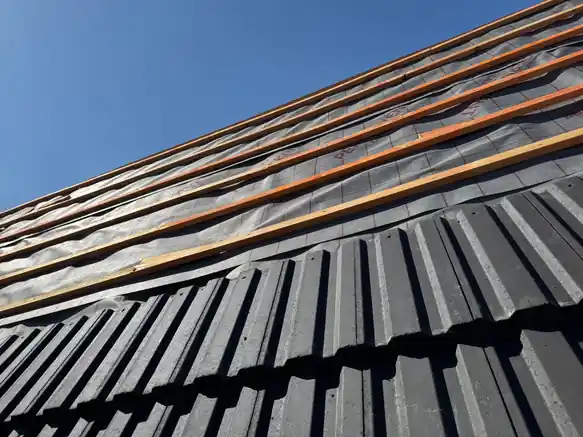 Grey tiles going on over new battens and membrane