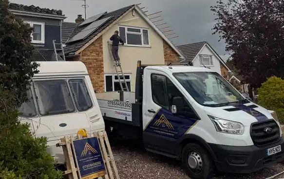 McDermott pickup on the drive while a roofer works from the ladder