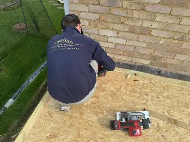 Roofer boarding an extension flat roof with OSB