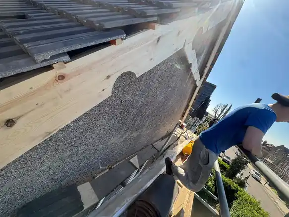 McDermott roofer working on a gable verge from the ladder