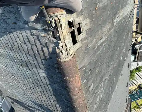 Slate roof repair beside a soil pipe, with the damaged section cut out