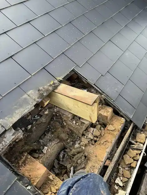 Slate roof opened up around a hole so the timbers underneath can be repaired