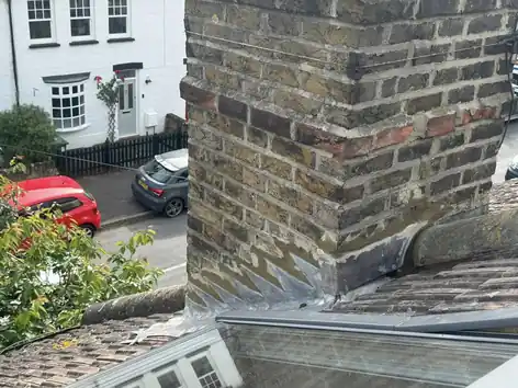 Lead flashing where a pitched roof meets a brick chimney stack