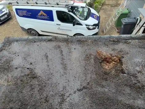 Worn flat roof before replacement, McDermott van below